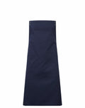 The PR190 apron by Premier features a classic design in navy blue, equipped with two large front pockets and adjustable top straps.