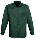 The Premier PR200 is a dark green button-up shirt with a collar and a single chest pocket on the left side. It features long sleeves and buttoned cuffs, presented against a plain white background.