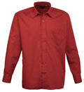The Premier PR200 is a red shirt featuring long sleeves, a button-up front, a collar, and a chest pocket, showcased against a plain white background.