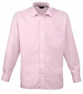 A light pink, long-sleeve dress shirt by Premier, identified as product PR200, featuring a pocket on the left side and a full button-up front. It has no visible patterns or logos, with a spread collar and appears to be crafted from cotton or similar fabric.