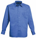 The Premier PR200 shirt, featuring a blue long-sleeve design with a chest pocket and classic collar, is showcased against a plain white background.