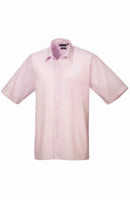 The Premier PR202 is a light pink short-sleeved button-up shirt featuring a front chest pocket, elegantly displayed against a plain white background.