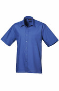 The Premier PR202 is a blue, short-sleeved shirt featuring a button-up design, collar, and single chest pocket.