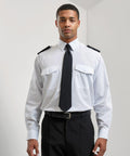 A man in a Premier PR210 pilot uniform with a white shirt, black tie, and black pants is standing against a plain white background.