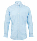 Premier's PR234 light blue long-sleeve button-down shirt, featuring a front pocket, is displayed on a white background.