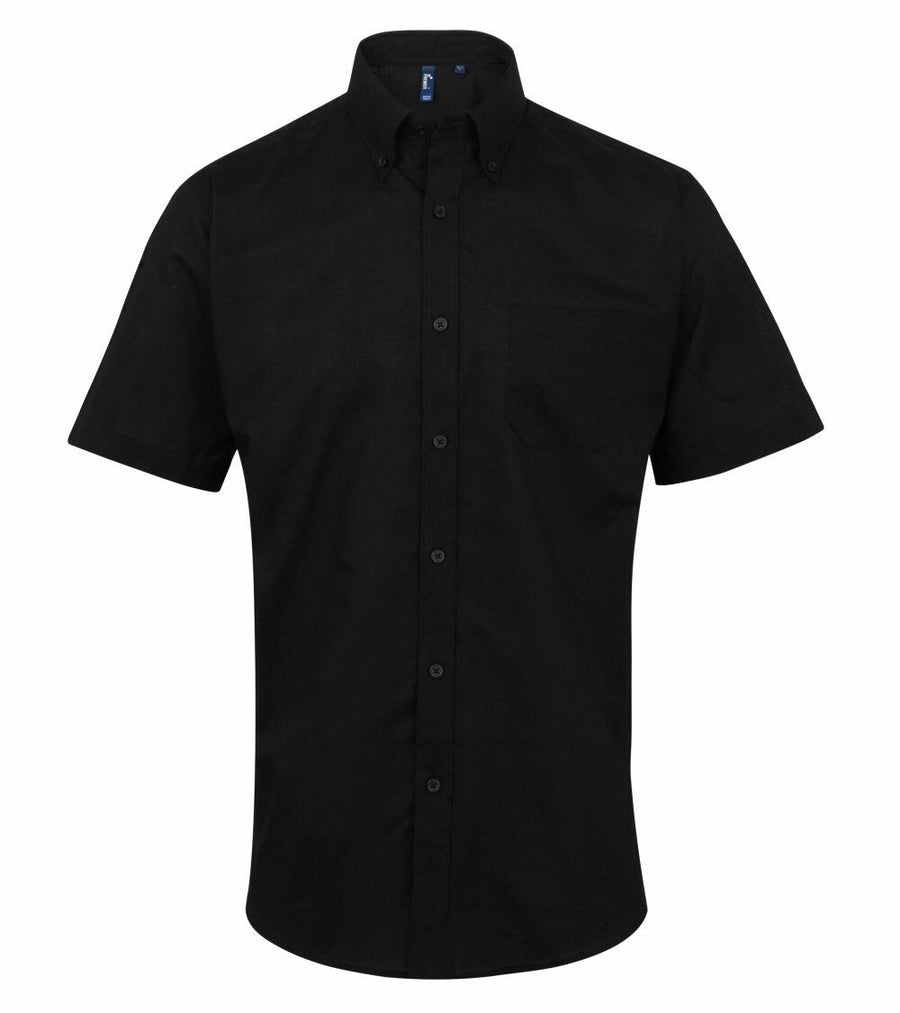 The Premier PR236 is a plain black short-sleeve button-up shirt featuring a collar and chest pocket.