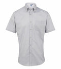 A light gray short-sleeve button-up shirt with a front pocket and a button-down collar by Premier, model PR236.