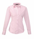 The PR300 by Premier is showcased against a white background, featuring a light pink color with long sleeves, a button-up design, a pointed collar, and cuffed sleeves for a formal and elegant look.
