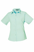PR302 by Premier: A light blue short-sleeve button-up shirt with a collar, showcased on a white background.