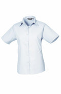 The Premier PR302 short-sleeved light blue button-up shirt with a collar is displayed against a white background.