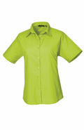 The product, PR302 from the brand Premier, is a vibrant green button-up shirt featuring short sleeves and a collar, showcased on a simple white background.