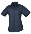 The Premier PR302 is a dark blue, short-sleeved button-up shirt showcased against a plain white background. It boasts a classic collar and has a smooth fabric finish, making it ideal for both casual and formal occasions.