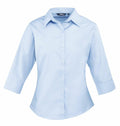 The PR305 by Premier is a light blue button-up shirt with three-quarter sleeves, neatly displayed against a plain background.