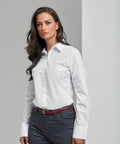 A person with long dark hair is wearing a white button-up shirt and gray pants, standing against a plain background, showcasing the PR307 by Premier.