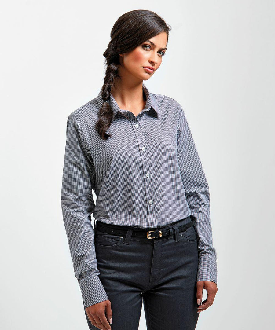 A woman with long, dark hair in a braid wears a light blue Premier PR320 button-up shirt and dark pants. She stands with her hands relaxed at her sides and looks slightly to her left.