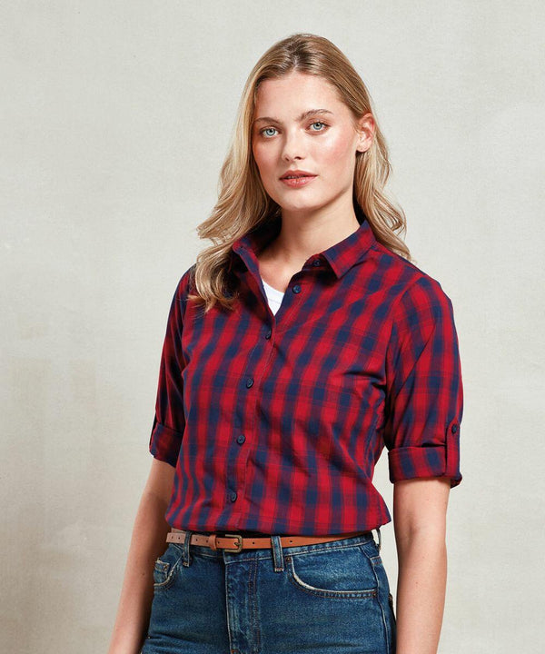 A woman with long blonde hair wearing a red and blue checkered shirt, rolled-up sleeves, and blue jeans stands in front of a plain background showcasing the Premier PR350.