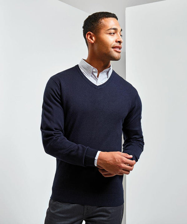 A man wearing a dark blue Premier PR400 over a light checkered shirt, standing against a plain, light background.