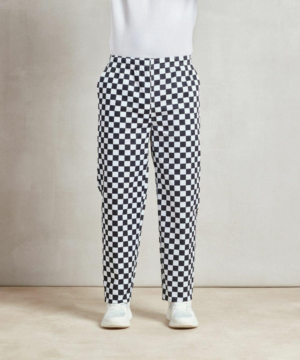 Person wearing Premier PR553 black and white checkered pants, a white top, and white shoes, standing against a neutral background.