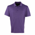 A plain purple Premier polo shirt, model PR615, features short sleeves and three buttons on the front. It is displayed against a white background.