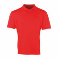 The Premier PR615 is a vibrant red short-sleeved polo shirt featuring a collar and three buttons down the front. It has a simple, classic design without any logos or embellishments, showcased on a white background.