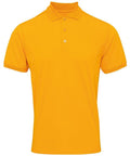 The Premier PR615 is a plain, bright orange polo shirt featuring short sleeves and a three-button placket, showcased against a white background.