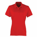 The Premier PR616 is a red short-sleeve polo shirt featuring a collar and three buttons. It is showcased on a plain white background, highlighting the front view.