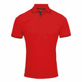 The Premier PR618 is a striking vibrant red polo shirt, complete with a collar and short sleeves accented by black trim on the sleeves and inner collar. This stylish piece is showcased against a sleek white backdrop.