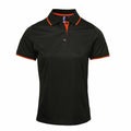 Premier's PR619 polo shirt in black, featuring a collar and orange accents along the edges and inner placket.