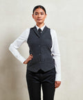 Person standing against a plain background, wearing a Premier PR626 white dress shirt, dark vest, dark pants, and a tie.
