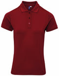 The Premier PR632 is a maroon polo shirt featuring a plain design, short sleeves, a collar, and three buttons.