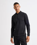 A man wearing the Premier Essential Coolchecker long sleeve chefs' shirt and black trousers stands facing the camera against a plain white background.