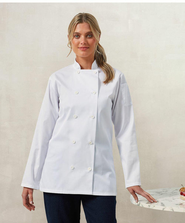 A person wearing a white chef's coat stands in front of a light background, resting one hand on a marble surface featuring Premier's PR671.