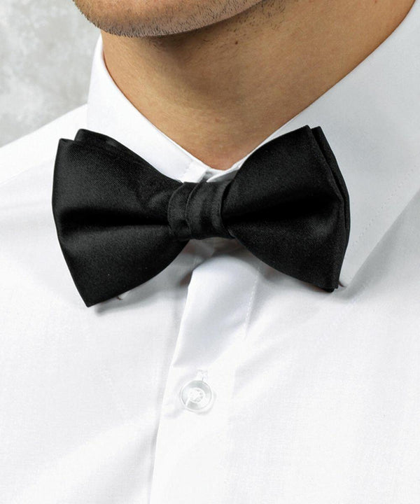 A close-up of a person wearing a white Premier PR705 dress shirt and a black bow tie.