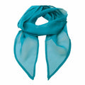 A vibrant Premier PR740 scarf in a stunning shade of teal is styled in a loose loop with its ends gracefully draping down. The translucent fabric suggests a lightweight, airy texture, making it perfect for adding a pop of color to any outfit.