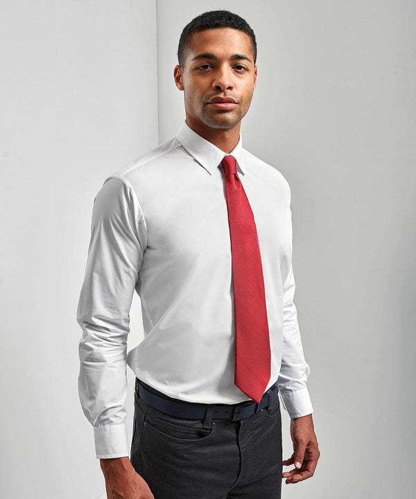 A person wearing a white PR765 dress shirt by Premier, a red tie, and dark trousers stands against a plain white background.
