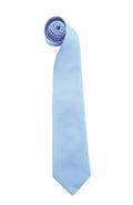 A light blue silk necktie from Premier, model PR765, is rolled at the narrow end and lies flat on a white background. It tapers to a pointed tip, showcasing its smooth texture and sheen.