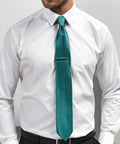 A person wearing a white Premier PR787 dress shirt and a teal tie with a subtle patterned design.
