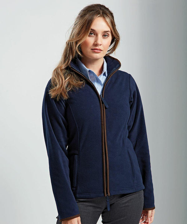 A person stands wearing a navy blue Premier PR824 zip-up jacket over a light blue collared shirt, facing the camera with a neutral expression.