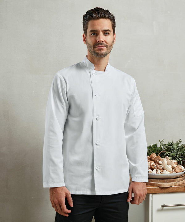 A chef in a white coat stands next to a countertop with various mushrooms, greens, and the Premier PR901.