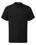 The Premier PR904 is a black short-sleeve shirt featuring a mandarin collar, buttoned front, and a single chest pocket on the left side.