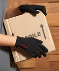 Person wearing black gloves holding and lifting a cardboard box labeled "Premier PR998" with upward arrows on its side.