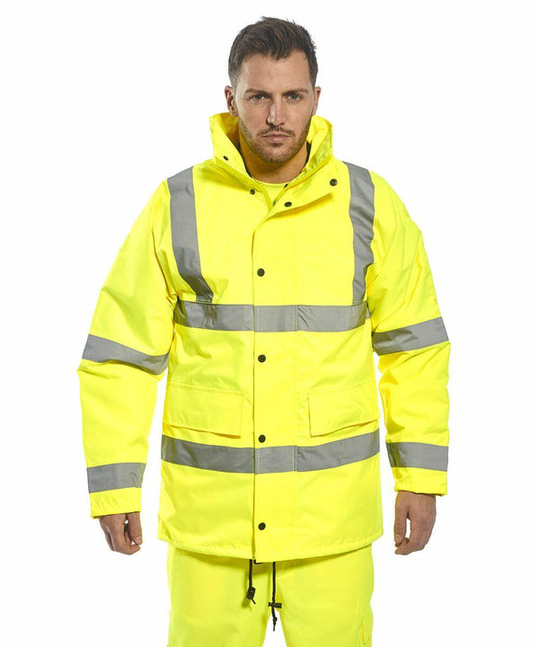 A man wearing a bright yellow Portwest PW003 with reflective stripes stands facing forward with a serious expression.