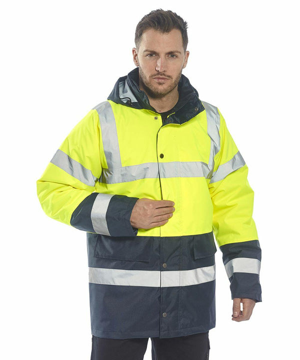 A person wearing a Portwest PW022 high-visibility yellow and blue jacket with reflective stripes.