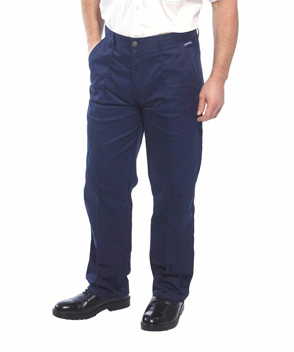 A person wearing navy blue Portwest PW105 pants and a white shirt, standing with hands in their pockets. The pants are straight-legged, and the person is also wearing black shoes.