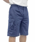 A person wearing blue Portwest PW122 cargo shorts and a white shirt, standing with hands behind their back. The shorts have multiple pockets.