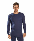 A man wearing a long-sleeved, dark blue thermal shirt and matching pants from Portwest's PW141 line stands facing forward.