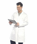A person in a white lab coat stands while using a Portwest PW175, looking at the screen with a slight smile.