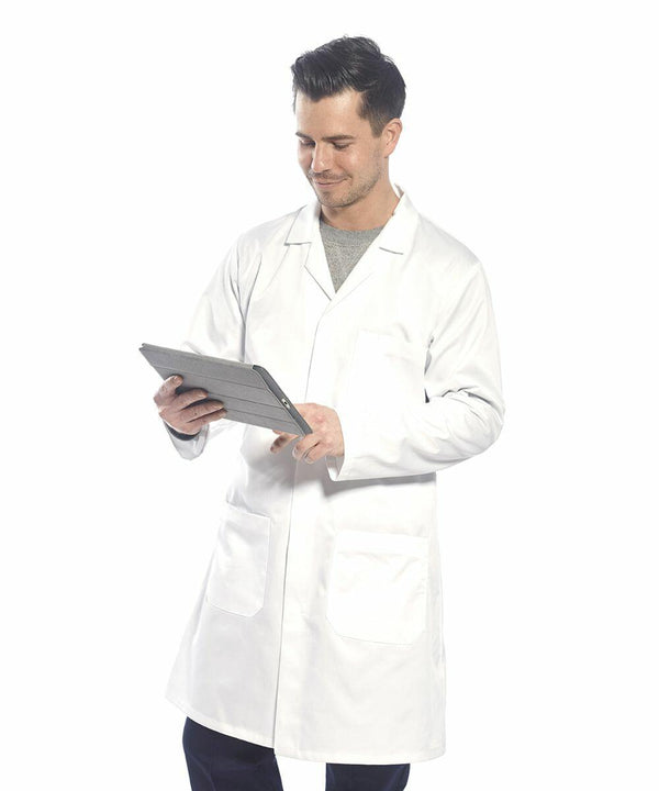 A person in a white lab coat stands while using a Portwest PW175, looking at the screen with a slight smile.