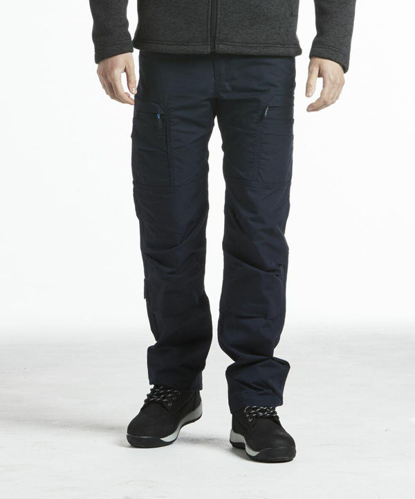 Man wearing dark blue PW290 cargo pants by Portwest and a dark sweater, standing against a plain white background.