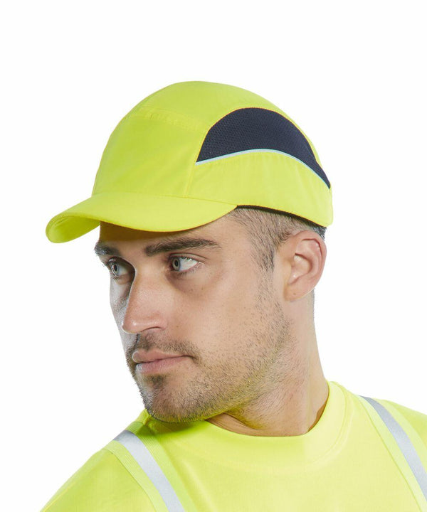 A man wearing a yellow safety cap and high-visibility Portwest PW362 shirt looks to the side.